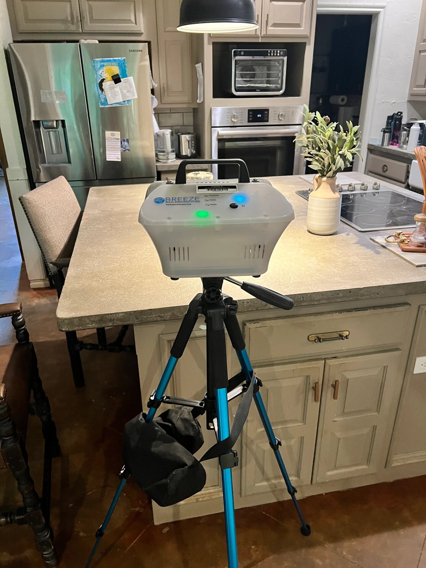 Radon test monitor on a tripod set up in a residential kitchen during a radon test in Oklahoma City