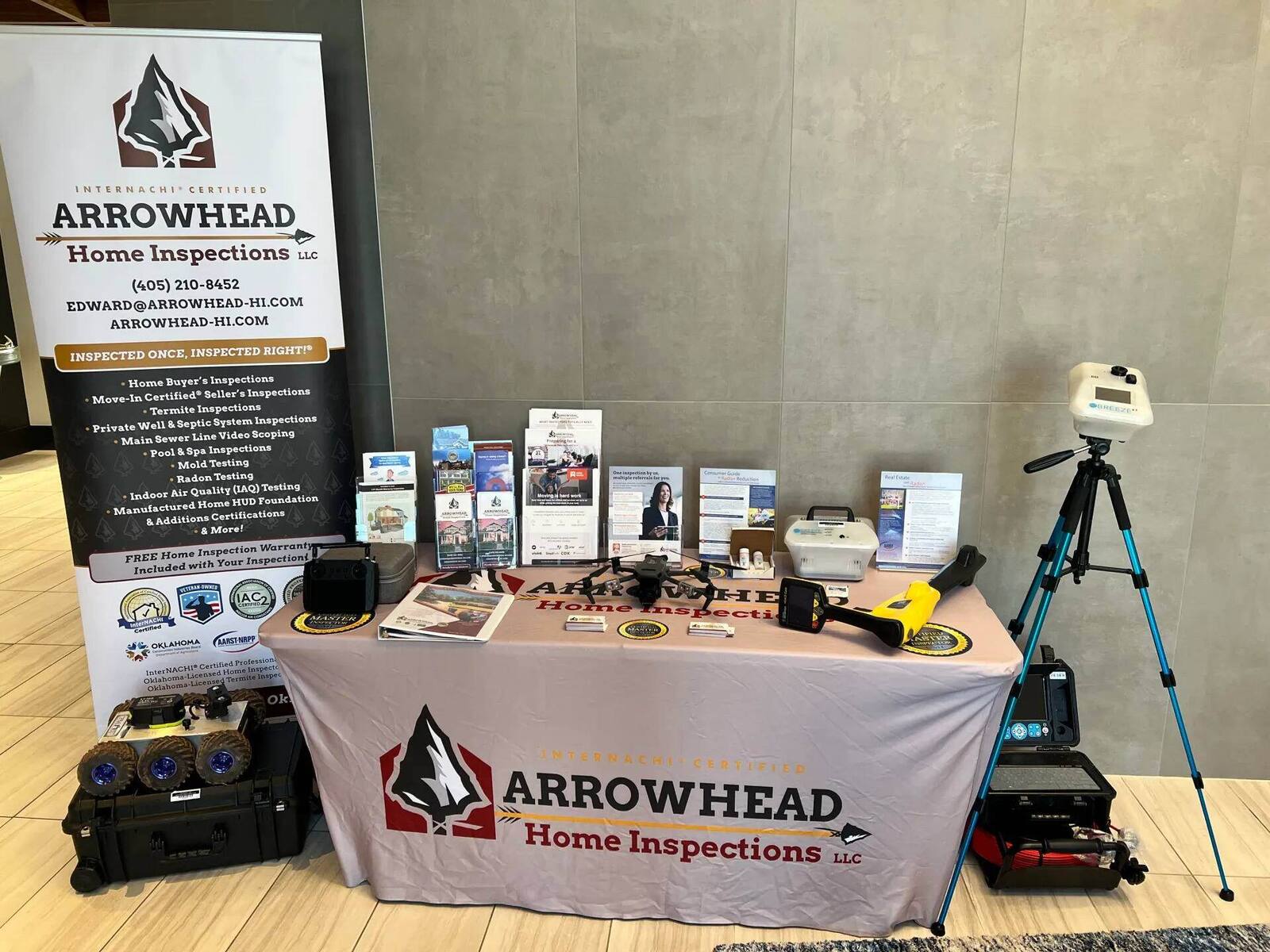 Arrowhead Home Inspections display table with inspection equipment, banner at a brokerage event