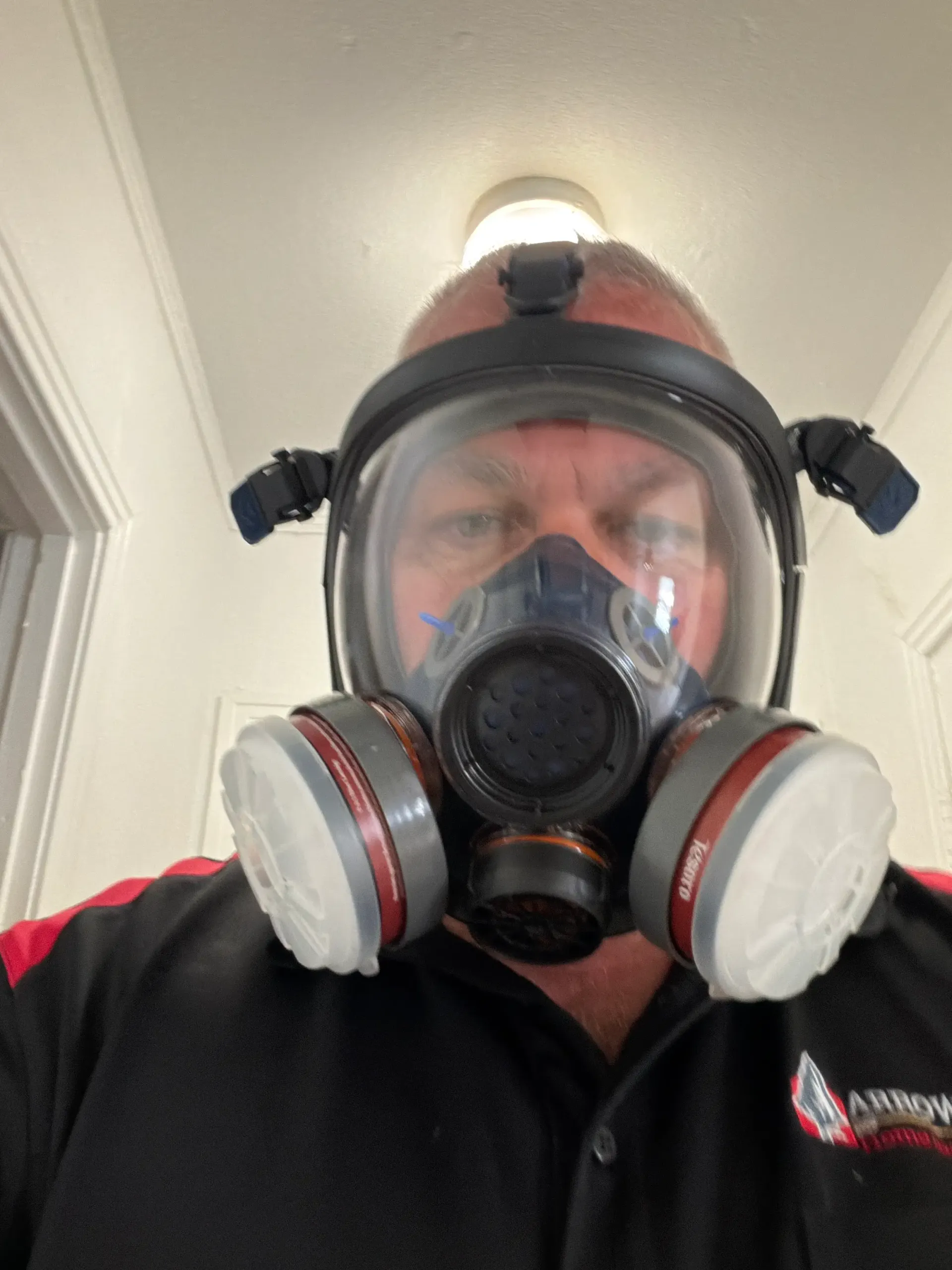 Inspector wearing a full-face respirator before entering an area with suspected air quality or mold concerns
