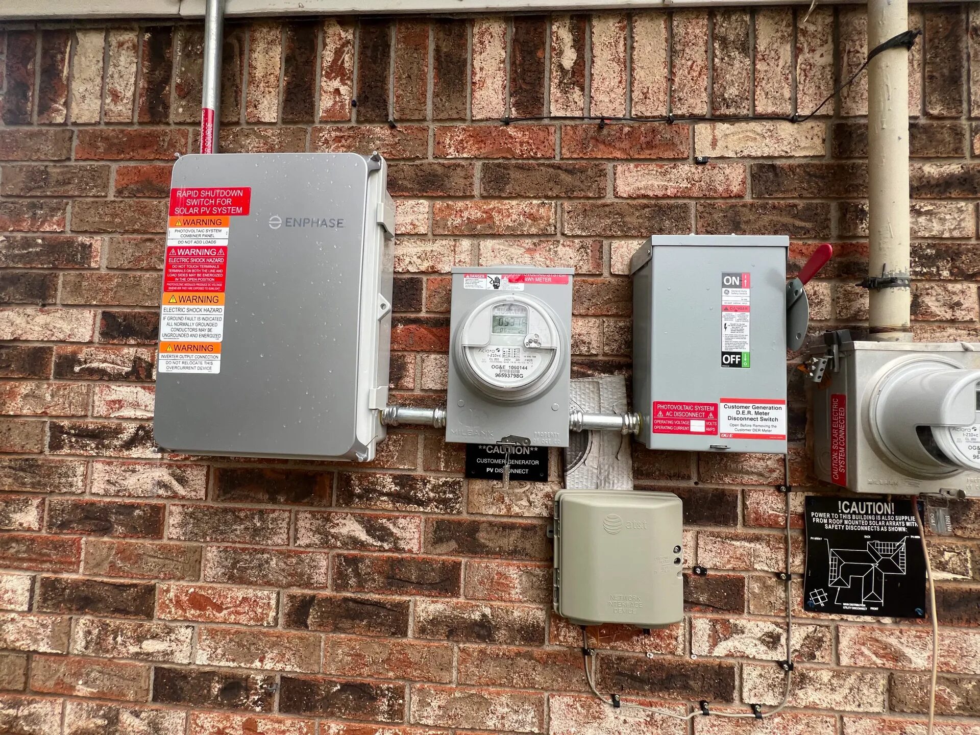 Exterior photovoltaic system rapid-shutdown and combiner equipment on a brick wall