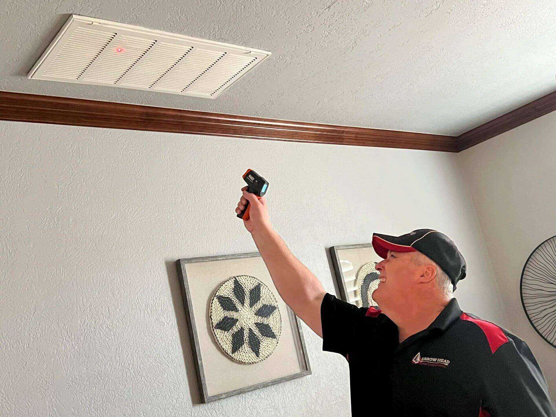 Edward Hagstrom using a thermal camera to inspect a ceiling vent